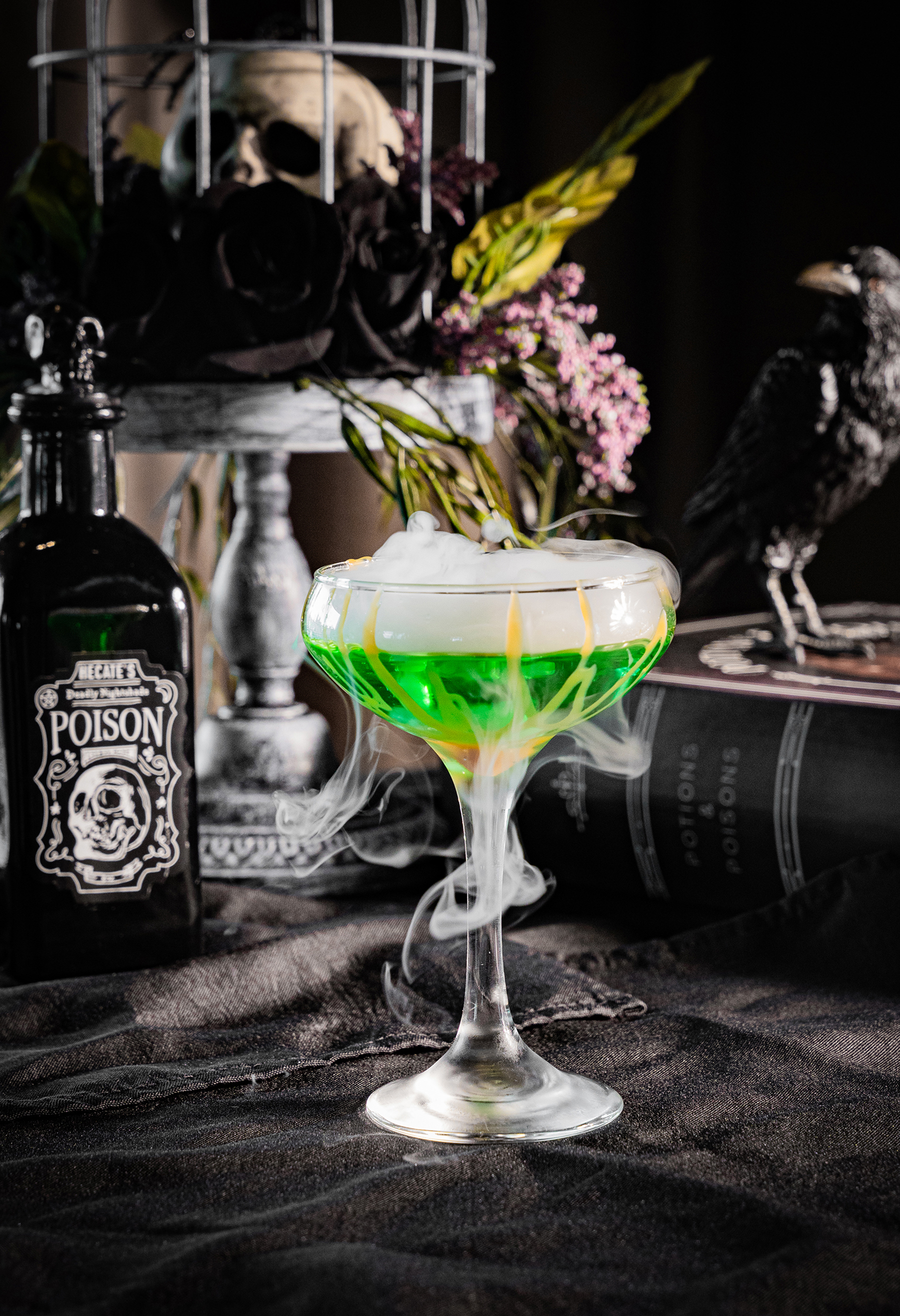 The Republic on Grand wine glass with lime green drink and spooky decorations in the background